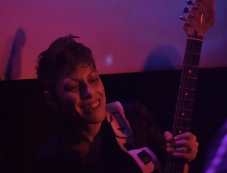 Antonella Vitanza tocando la guitarra en vivo con la banda Quiero Cumbia