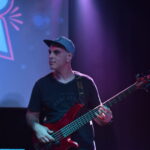 Bajista de Quiero Cumbia tocando en el escenario durante un show en vivo