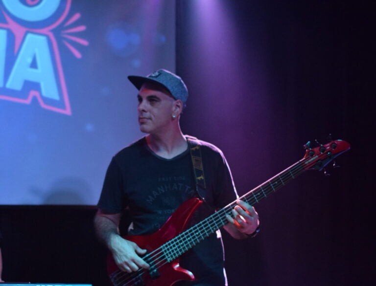 Bajista de Quiero Cumbia tocando en el escenario durante un show en vivo