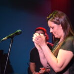 Cantante de Quiero Cumbia marcando el ritmo con las manos durante un show en vivo